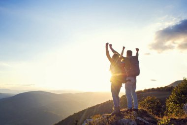 Mutlu çift, yaz yürüyüşü sırasında gün batımında dağın tepesinde gezen turist.
