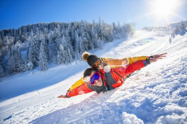 Arkadaşlar kışın taze karda eğlenir.