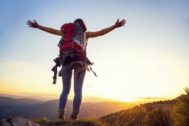 Tezahüratçı kadın dağların zirvesinde kollarını açtı.