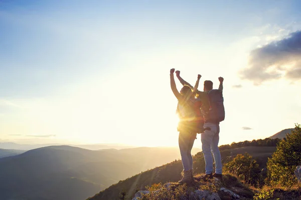 Щаслива пара чоловік і жінка турист на вершині гори на заході сонця на відкритому повітрі під час походу влітку — стокове фото