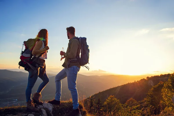 Jeune couple se promenant sur le sommet de l'eau potable de montagne — Photo