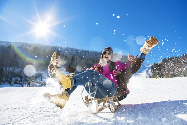 Jovem casal feliz trenó no inverno no centro de esqui — Fotografia de Stock