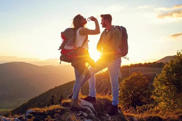 Young Couple Hiking On The Peak of Mountain drinking water — Stock Photo, Image