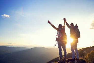 Mutlu çift, yaz yürüyüşü sırasında gün batımında dağın tepesinde gezen turist.