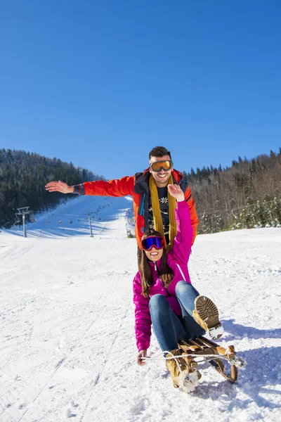 Joven feliz pareja en sledge tener divertido —  Fotos de Stock