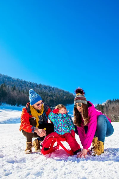 Família feliz na neve equitação no trenó . — Fotografia de Stock