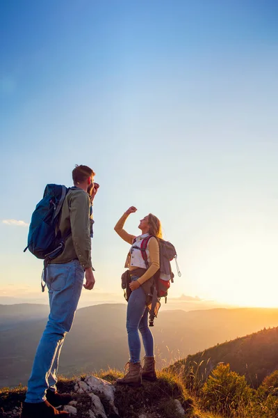 Paar op de top van een berg schudden opgeheven handen — Stockfoto