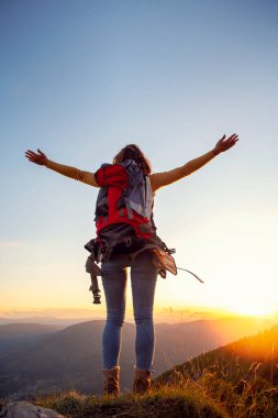 Tezahüratçı kadın dağların zirvesinde kollarını açtı.