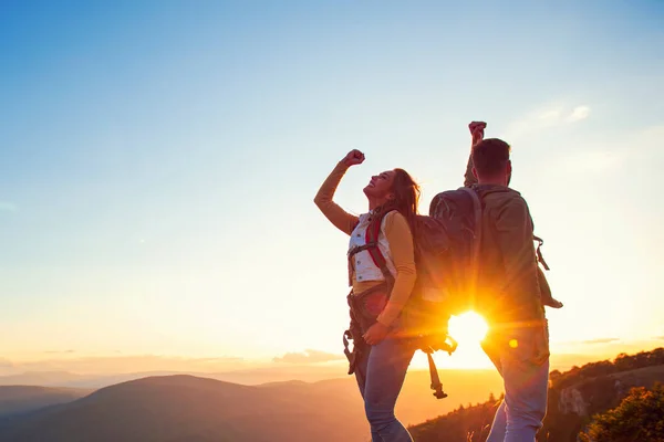 Paar op de top van een berg schudden opgeheven handen — Stockfoto