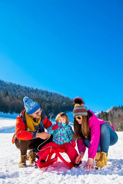 Família feliz na neve equitação no trenó . — Fotografia de Stock