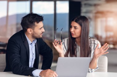 Ofiste oturup dizüstü bilgisayarla çalışırken iş tartışan birkaç meslektaşım var.