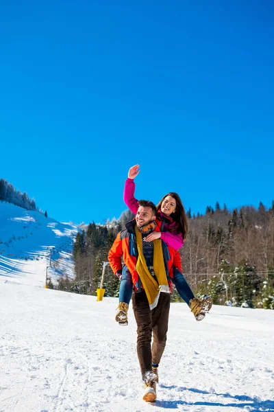 Casal feliz se divertindo sobre fundo de inverno — Fotografia de Stock