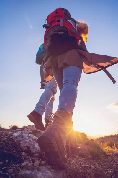 Toeristisch koppel draagt wandelschoenen lopen een grazige heuvel in de Alpen. — Stockfoto