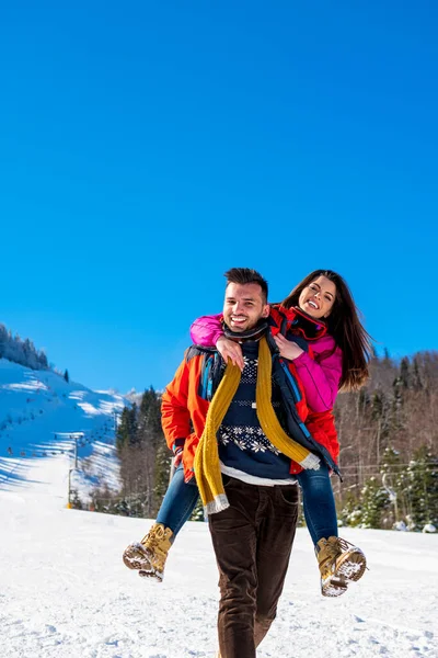 Casal feliz se divertindo sobre fundo de inverno — Fotografia de Stock