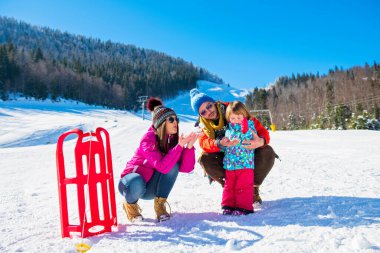 Kar Altında Mutlu Aile Sledge Sürüyor.