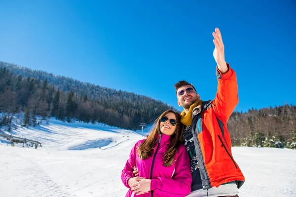 Winter snow couple love story.Beautiful girl in cozy hat and handsome bearded man hugs each other. pullover with. — Stock Photo, Image