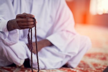 Dindar siyah Müslüman adam camide dua ediyor.