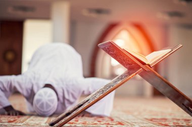 Dindar siyah Müslüman adam camide dua ediyor.