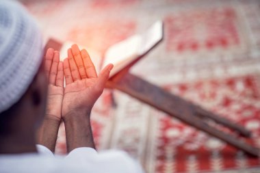 Dindar siyah Müslüman adam camide dua ediyor.