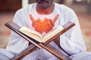 Dindar siyah Müslüman adam camide dua ediyor.