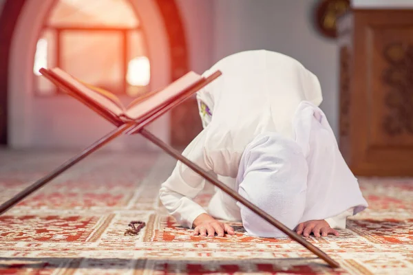 Jovem mulher muçulmana lendo Alcorão na mesquita e luz solar caindo da janela — Fotografia de Stock