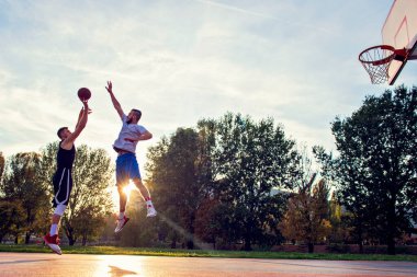 İki sokak basketbolcusu sahada sıkı oynuyor.