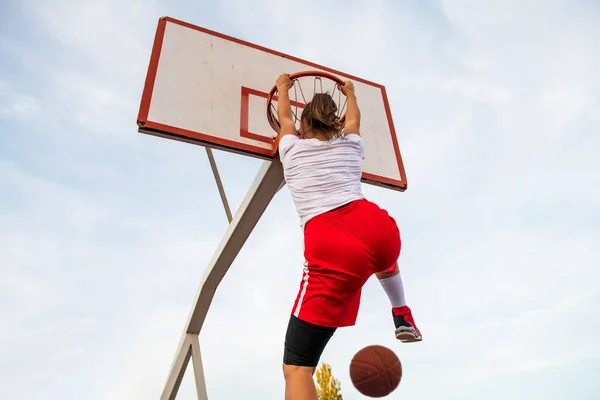 여성들이 길거리 코트에서 농구를 하고 있습니다. 농구 경기에서 슬램 덩크를 하는 여자 전차 선수. — 스톡 사진