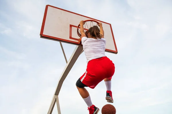 Samice hrají basketbal na pouličním hřišti. Žena streetball hráč dělat slam ponořit do basketbalové hry. — Stock fotografie