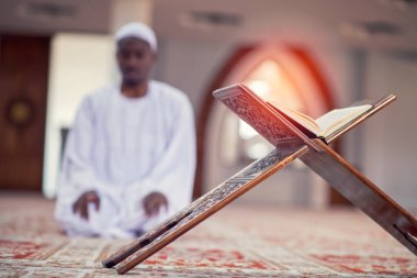 Dindar siyah Müslüman adam camide dua ediyor.