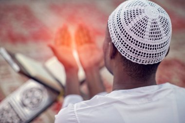 Dindar siyah Müslüman adam camide dua ediyor.