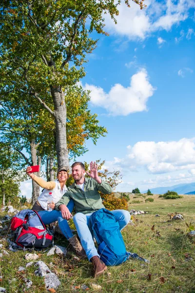 Veselý mladý pár se selfie venku během cestování v horách — Stock fotografie