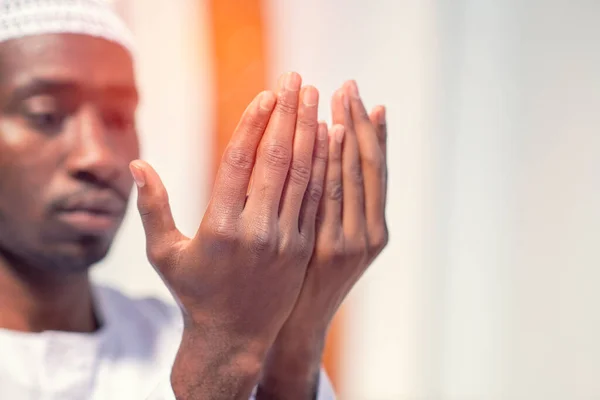 Religious black muslim man praying inside the mosque