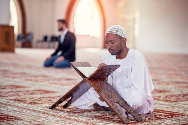 Dindar siyah Müslüman adam camide dua ediyor.