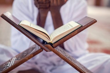 Dindar siyah Müslüman adam camide dua ediyor.