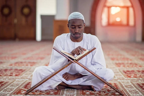 Religious black muslim man praying inside the mosque