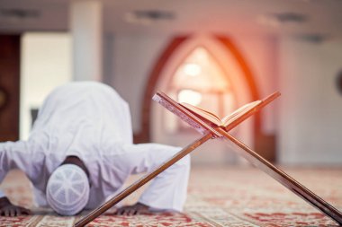 Dindar siyah Müslüman adam camide dua ediyor.