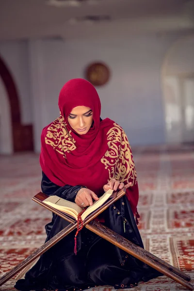 Joven musulmana leyendo el Corán en la mezquita y la luz del sol cayendo de la ventana — Foto de Stock