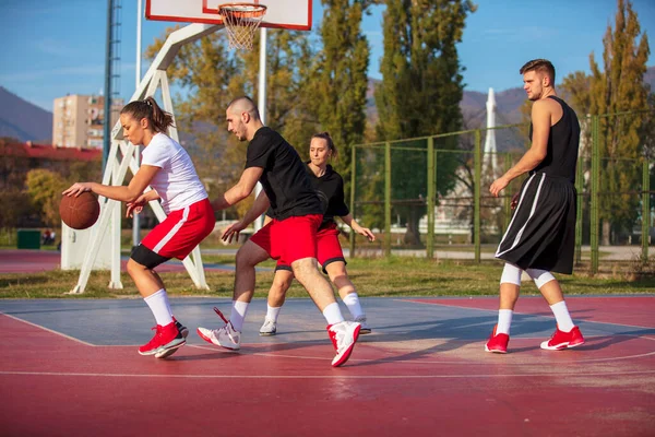 Группа молодых друзей, играющих в баскетбол — стоковое фото