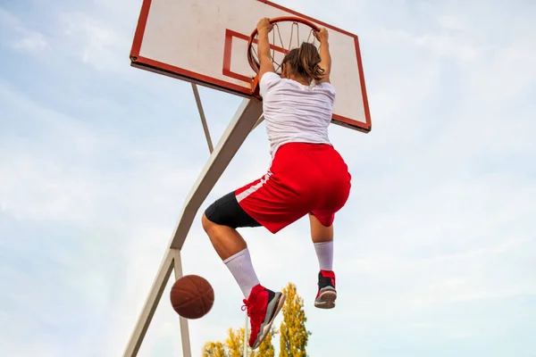 Fêmeas jogando basquete na quadra de rua. Mulher jogador de streetball fazendo slam dunk em um jogo de basquete. — Fotografia de Stock