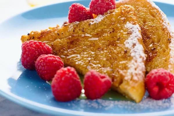 Zwei Stücke French Toas mit Zucker, Honig und Himbeeren — Stockfoto