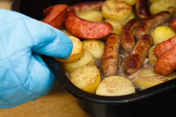 Blachę z roaste kiełbaski i ziemniaki — Zdjęcie stockowe