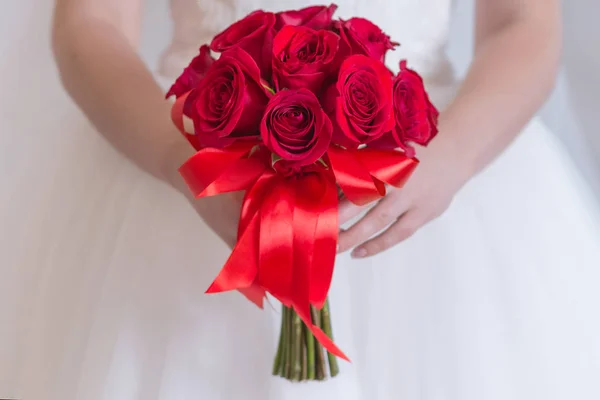 El ramo de rosas rojo brillante de la boda en las manos de una muchacha de cerca — Foto de Stock