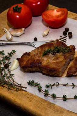 Baharatlar ve sebzeler ile ahşap bir eski kesme tahtası üzerinde sulu biftek biftek. Siyah bir arka plan üzerinde restoran menüleri için metin tasarım için. Gıda arka plan.