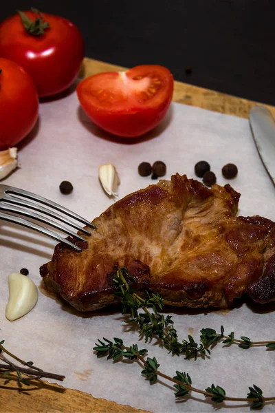 Baharatlar ve sebzeler ile ahşap bir eski kesme tahtası üzerinde sulu biftek biftek. Siyah bir arka plan üzerinde restoran menüleri için metin tasarım için. Gıda arka plan.