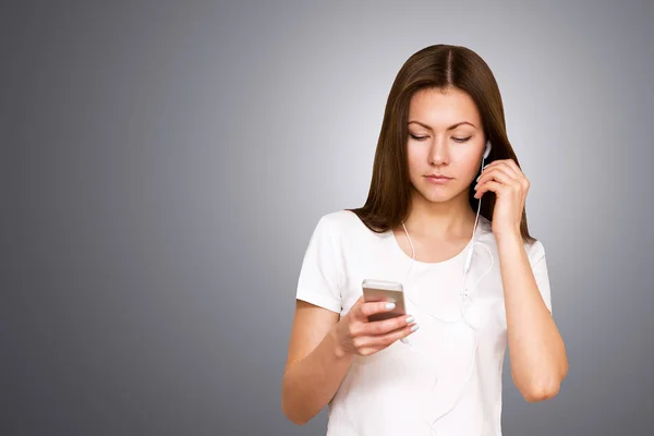 Beautiful attractive casual young woman talking on her mobile phone. Studio shot over gray background. — Stock Photo, Image