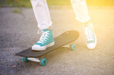 Güzel güzel kız ile karayolu Longboard doğal Street üzerinde gidiyor. Güneş tonlama. Bir yakın çekim portre