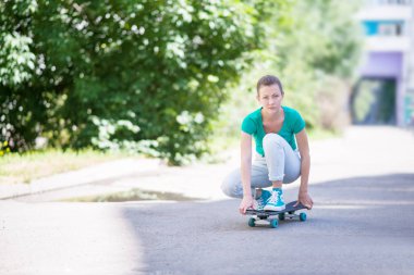 Güzel güzel kız ile karayolu Longboard doğal Street üzerinde gidiyor. Güneş tonlama. Bir yakın çekim portre
