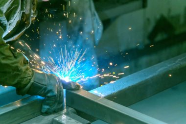 Kaynakçı, yarı otomatik kaynaklama ile kaynak işi yapıyor. Kaynağı olmayan çelik borular. Kaynak Mig.