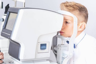 Bir optometrist ya da optometrist retina, göz lensi ve göz içi basıncı özel göz doktoru ekipmanları üzerinde teşhis eder. Beyaz gömlekli bir öğrenci.