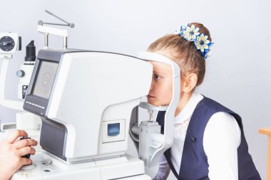 Bir optometrist ya da optometrist retina, göz lensi ve göz içi basıncı özel göz doktoru ekipmanları üzerinde teşhis eder. Beyaz bluzlu kız öğrenci.